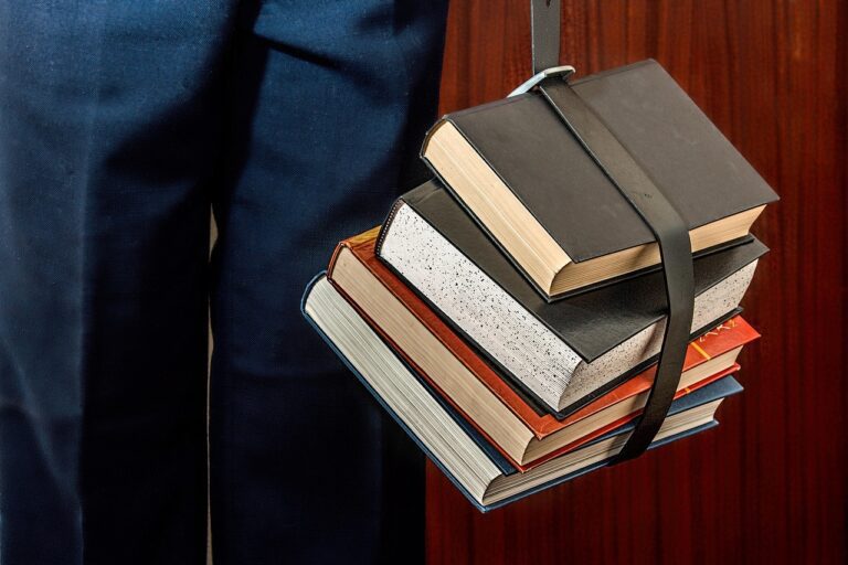 Pilha de livros e material escolar representando a preparação para o concurso PM SP 2026 com conteúdo programático completo do Anexo B do Edital DP-3/321/26