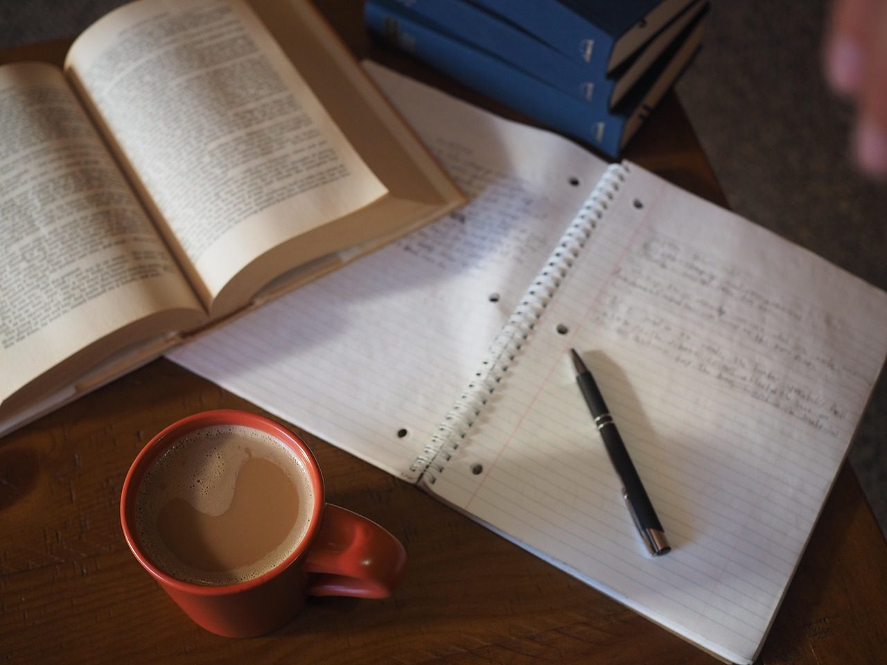 Estudante com caderno e café montando plano de estudos para a banca Vunesp do concurso PM SP