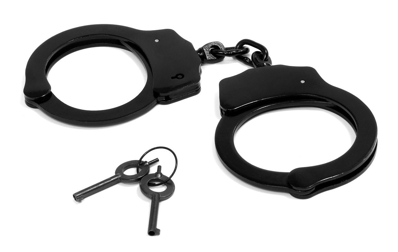 Algemas sobre superfície escura representando a prisão em flagrante feita pela guarda municipal