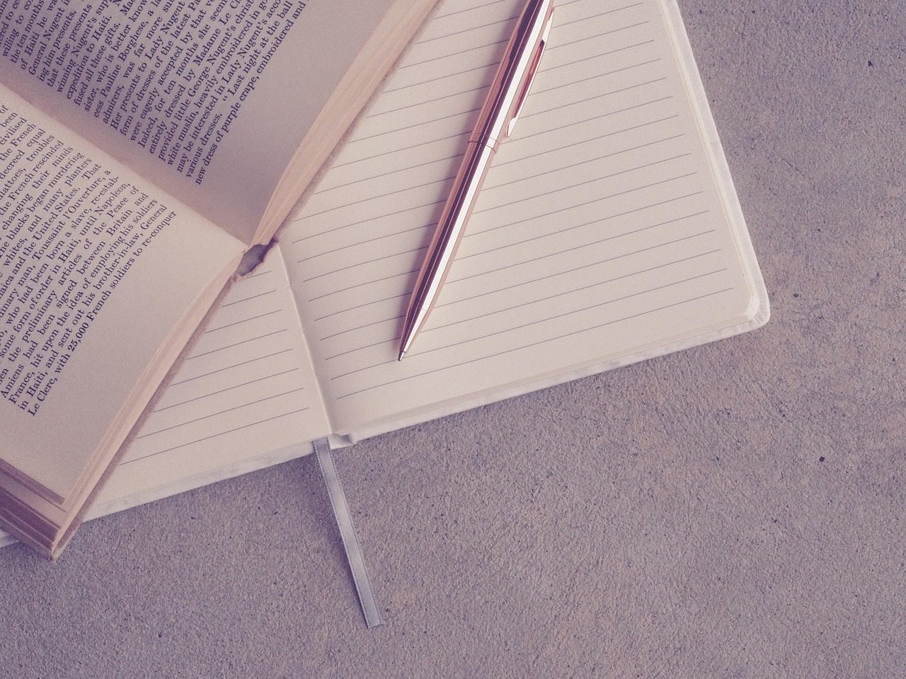 Caderno aberto com caneta para treino de redação dissertativa do concurso PM SP Vunesp